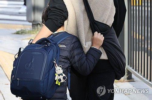 엄마품에 안겨 등교하는 어린이