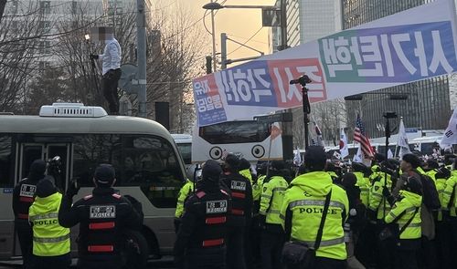 경찰 버스에 올라간 시위자