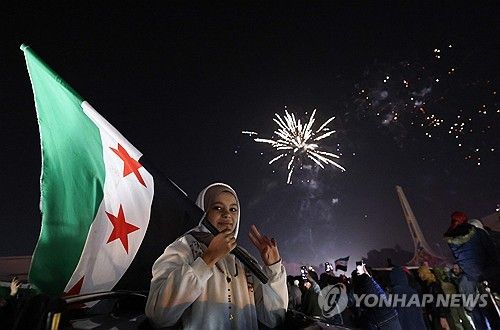 새해 맞아 거리에 깃발 들고 나선 시리아 여성
