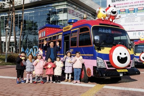 마포순환열차버스 앞에서 어린이들과 함께한 박강수 구청장(2025.1.17)