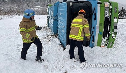 지난 6일 오전 강원 춘천시 서면 당림리 마을회관 인근에서 쓰레기 수거 차량이 눈길에 미끄러져 소방대원들이 구조 작업을 벌이는 모습. [강원특별자치도소방본부 제공. 재판매 및 DB 금지]