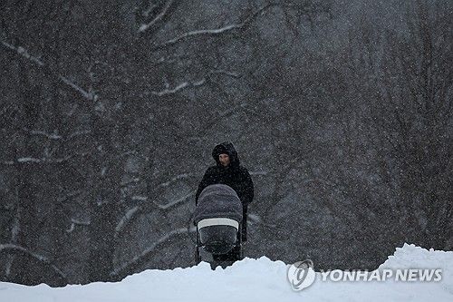 눈길에서 아기와 산책하는 러시아 여성