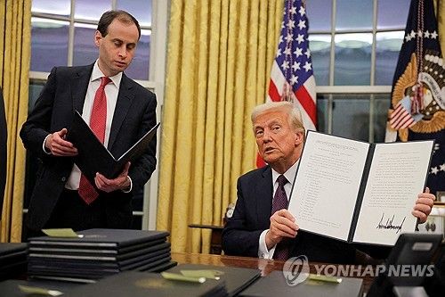 도널드 트럼프 미국 대통령이 지난 20일 서명한 행정명령을 들어보이는 모습