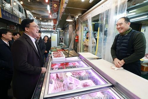 김병환 금융위원장이 설 명절을 앞둔 23일 오후 서울 종로구 전통시장인 통인시장을 방문해 고기·한과 등을 직접 구입하며 최근 전통시장 경기 및 상인들의 애로사항을 듣고 민생금융지원 방안에 대해 이야기를 나눴다.[금융위 제공]