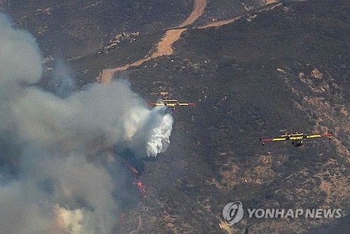 23일 LA 북부 캐스테이크호 인근에서 '휴스 산불' 진화 중인 항공기