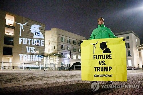 그린피스 활동가가 21일(현지시간) 독일 베를린 주독일 미국 대사관 앞에서 '미래 대 트럼프'라고 쓰인 배너를 들고 도널드 트럼프 대통령의 파리협정 탈퇴 방침에 항의하고 있다. [EPA=연합뉴스 자료사진]