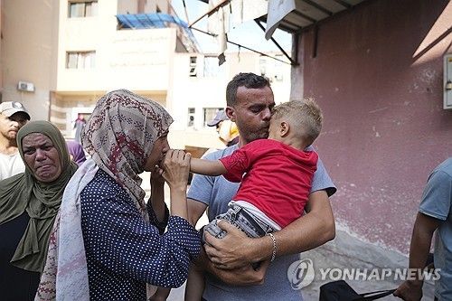 치료를 위해 후송되는 아이와 인사를 나누는 팔레스타인 부모