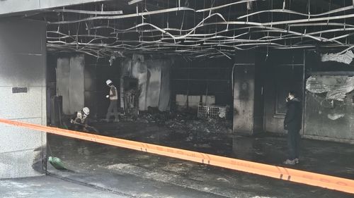 화재 잔해물을 치우는 작업이 진행 중인 1층 주차장 