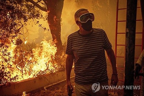 7일(현지시간) 산불이 확산 중인 미 LA 퍼시픽 팰리세이즈에서 걸어나오는 주민