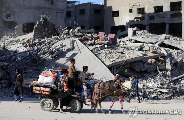 11일(현지시간) 폐허가 된 가자시티로 들어서는 팔레스타인인들