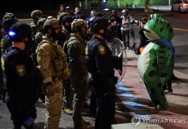 포틀랜드에서 개구리 복장으로 ICE 요원과 대치 중인 한 시위자 