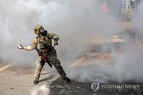 시카고 남부 주택가에서 최루가스를 던지는 이민당국 요원