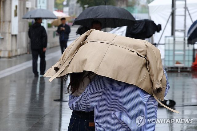 서울 종로구 광화문광장에서 시민들이 옷으로 머리를 가린채 달리고 있다. [연합뉴스 자료사진]