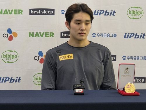 메달 케이스를 바라보는 김우민