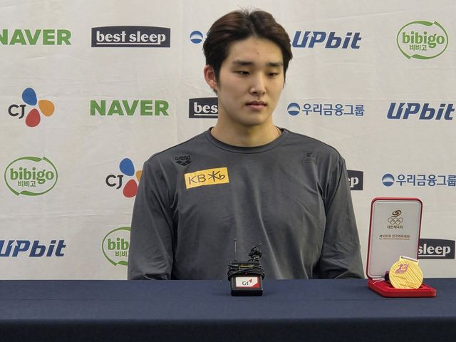 메달 케이스를 바라보는 김우민