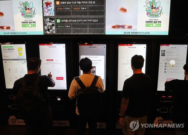 서울의 한 영화관 키오스크에서 티켓 예매하는 시민들