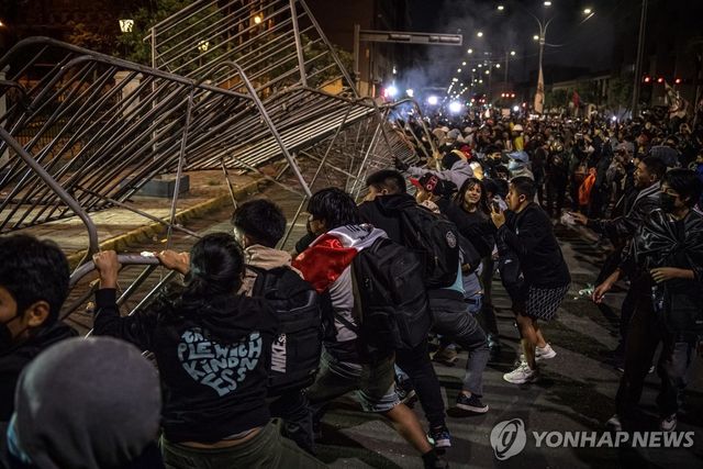 지난 9월 28일 페루 리마에서 열린 시위 도중 시위 참가자들이 펜스를 무너뜨리고 있다.[EPA=연합뉴스. 재판매 및 DB 금지]