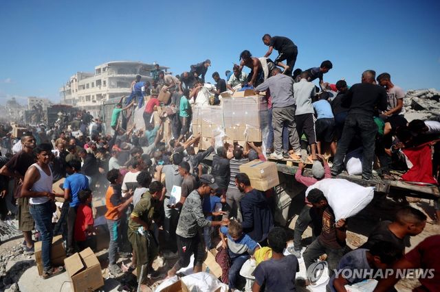 구호 트럭에서 구호품 상자를 수령하는 팔레스타인 주민들