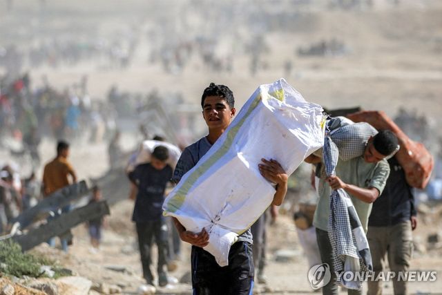 가자지구에서 구호물자 들고 가는 팔레스타인 소년