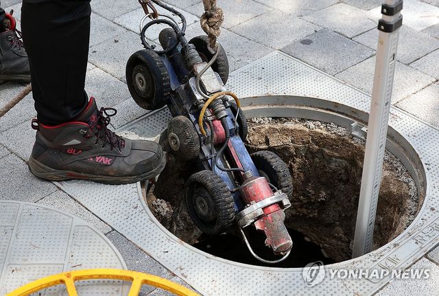 지난 8월 12일 서울 중구 동대문역사문화공원역 인근에서 서울시 물재생계획과 관계자들이 지반침하 예방 방지차원으로 30년 이상 원형 하수관로를 CCTV 자주차를 이용해 전수조사 하고 있다. [연합뉴스 자료사진]