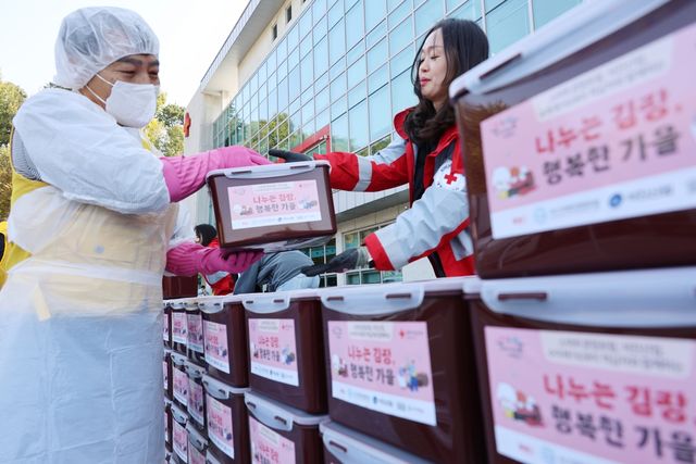 (청주=연합뉴스) 박건영 기자 = 대한적십자사 충북지사 봉사회원들이 29일 청주시 흥덕구 적십자 충북지사 앞마당에서 열린 '사랑 더하기, 김장 나누기' 행사에서 김장김치를 옮기고 있다. 2025.10.29