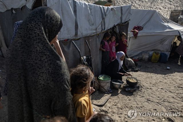 가자지구 칸유니스 난민촌에서 요리하는 여성과 아이들