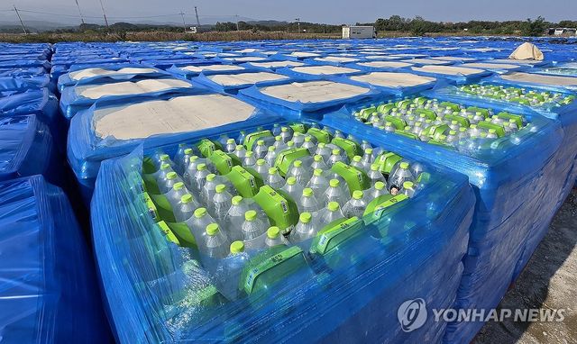 야외 주차장서 햇볕·비바람에 노출된 기부받은 생수