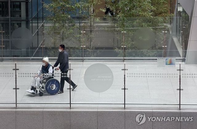 휠체어 타고 이동하는 환자. 기사 내용과 직접적인 관련 없음. 