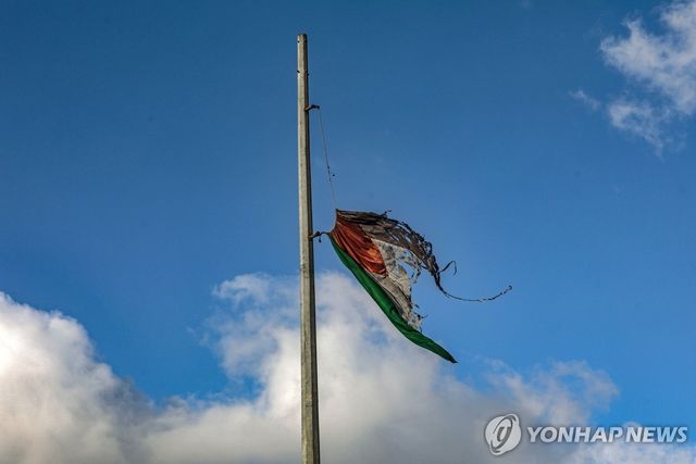 5일(현지시간) 이스라엘군의 공습이 계속되는 동안 가자시티에 걸린 팔레스타인 국기가 휘날리고 있다. 