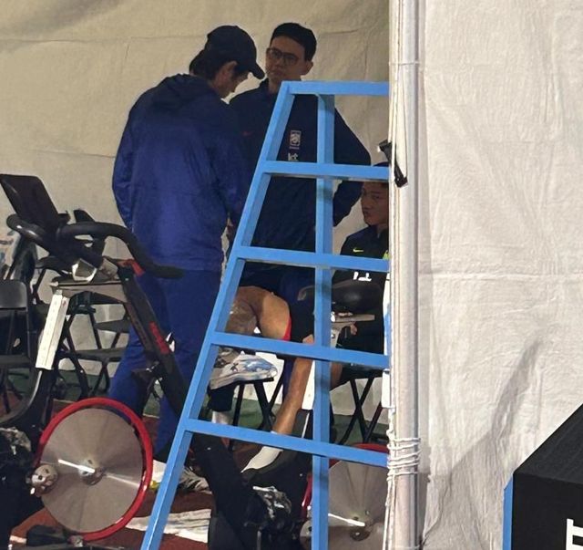 종아리에 얼음찜질을 하는 황희찬의 상태를 확인하는 홍명보 감독