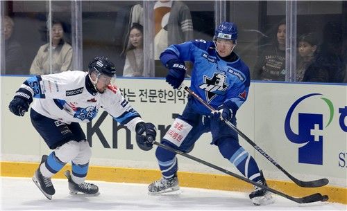 상대 선수와 퍽을 다투는 HL 안양 김상욱(오른쪽)