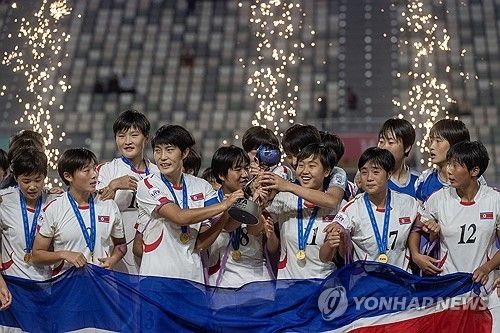 우승 트로피를 들고 기뻐하는 북한 U-17 여자 축구대표팀 선수들