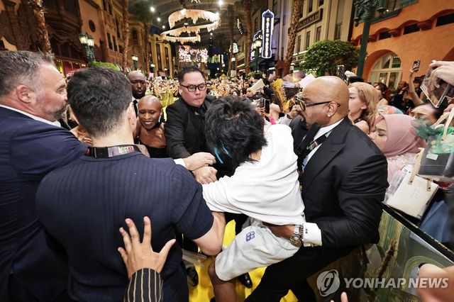 지난 13일 싱가포르 행사에서 물의를 일으키고 끌려가는 존슨 웬