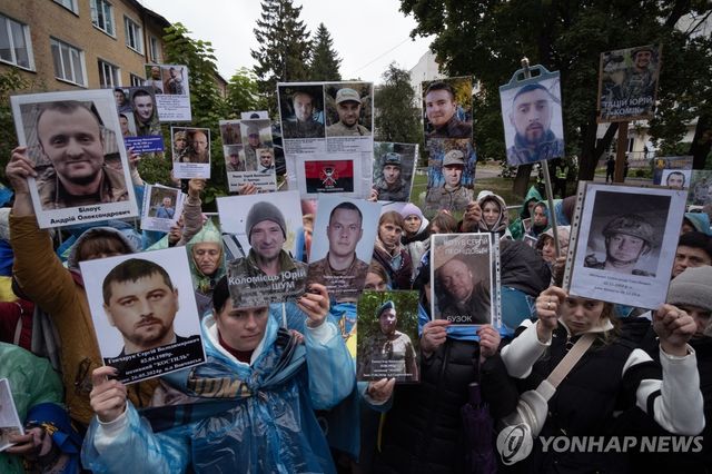 전쟁포로 사진 들고 있는 우크라이나 시민들