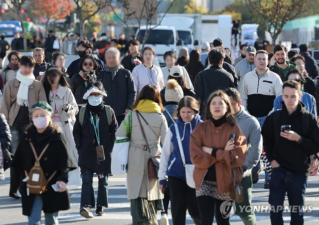 2일 서울 광화문 광장에서 시민 및 외국인 관광객들이 외투를 입은 채 걸어가고 있다. [연합뉴스 자료사진]