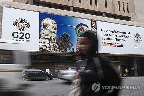 20일(현지시간) 요하네스버그 시내의 G20 광고판 앞을 지나가는 여성