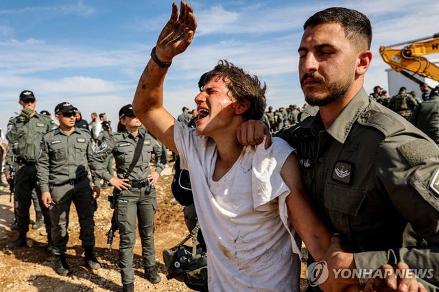 지난 17일(현지시간) 이스라엘 국경경찰이 요르단강 서안에 불법 정착촌 전초기지를 세운 유대인을 제압하고 있다. 