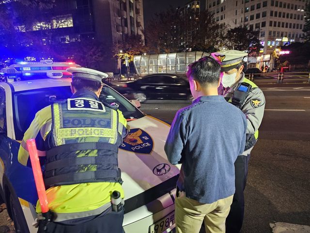 21일 서울 유흥가에서 경찰이 실시한 음주 단속에서 한 운전자가 혈중알코올농도를 측정한 뒤 경찰과 대화를 나누는 모습 [촬영 김동한 수습기자]