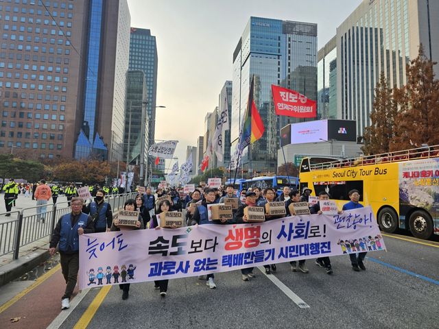 23일 서울 광화문 동십자각 인근에서 '과로사 없는 택배 만들기 시민대행진' 참여자들이 행진하는 모습. [촬영 김동한 수습기자]