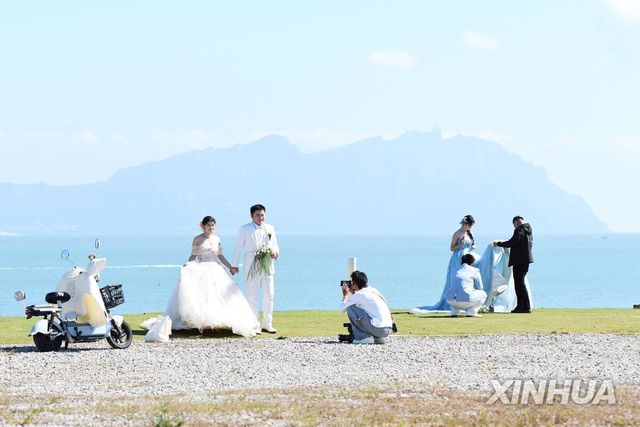 중국 산둥성 칭다오 링산만에서 웨딩촬영하는 커플들