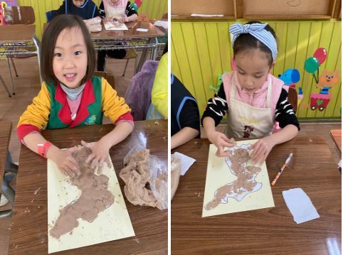 반죽된 흙으로 한반도 지도 만들고 있는 어린이들