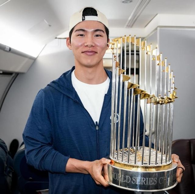 구단 전세기에서 우승 트로피 들고 포즈 취하는 김혜성