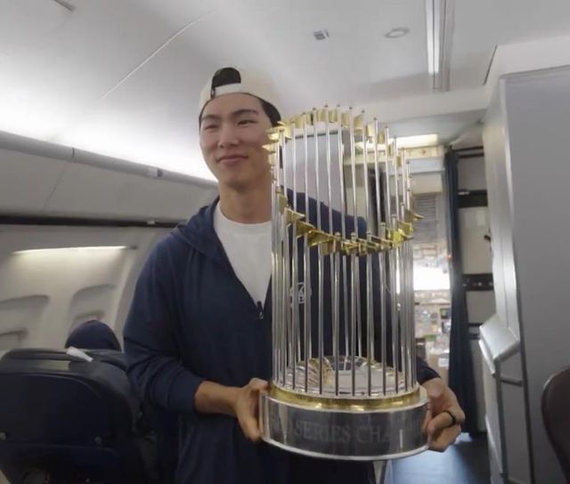 구단 전세기에서 우승 트로피 들고 포즈 취하는 김혜성