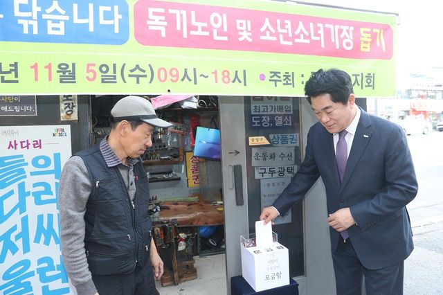 관악구 사랑의 구두닦이 행사에서 모금함에 기부하는 박준희 구청장