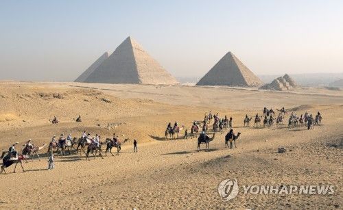 이집트의 피라미드와 낙타 행렬