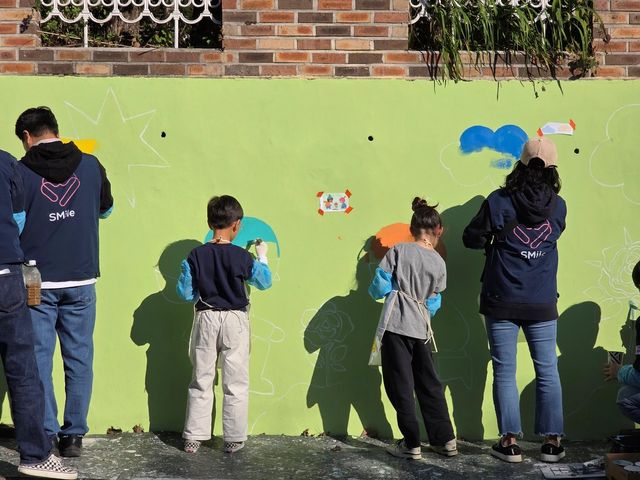 SM엔터테인먼트 봉사단 등이 벽화를 조성하는 모습
