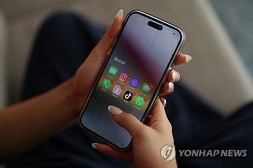 휴대전화 손에 든 호주 청소년