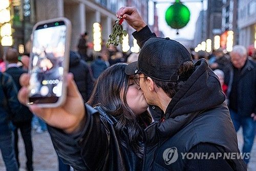 13일 워싱턴DC의 '내셔널 겨우살이' 아래서 키스하는 커플