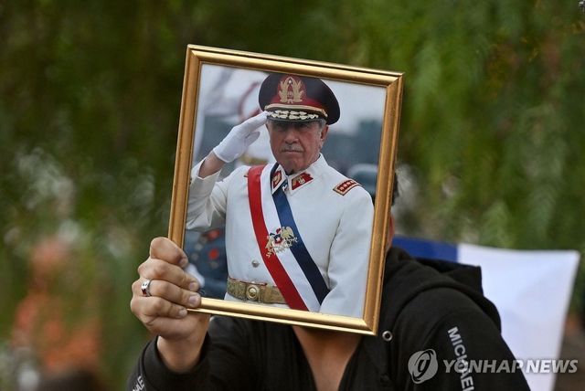 14일(현지시간) 칠레 군부 독재자 피노체트 사진 들고 나온 주민