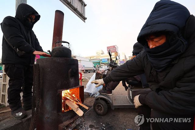 강추위에 몸 녹이는 상인들